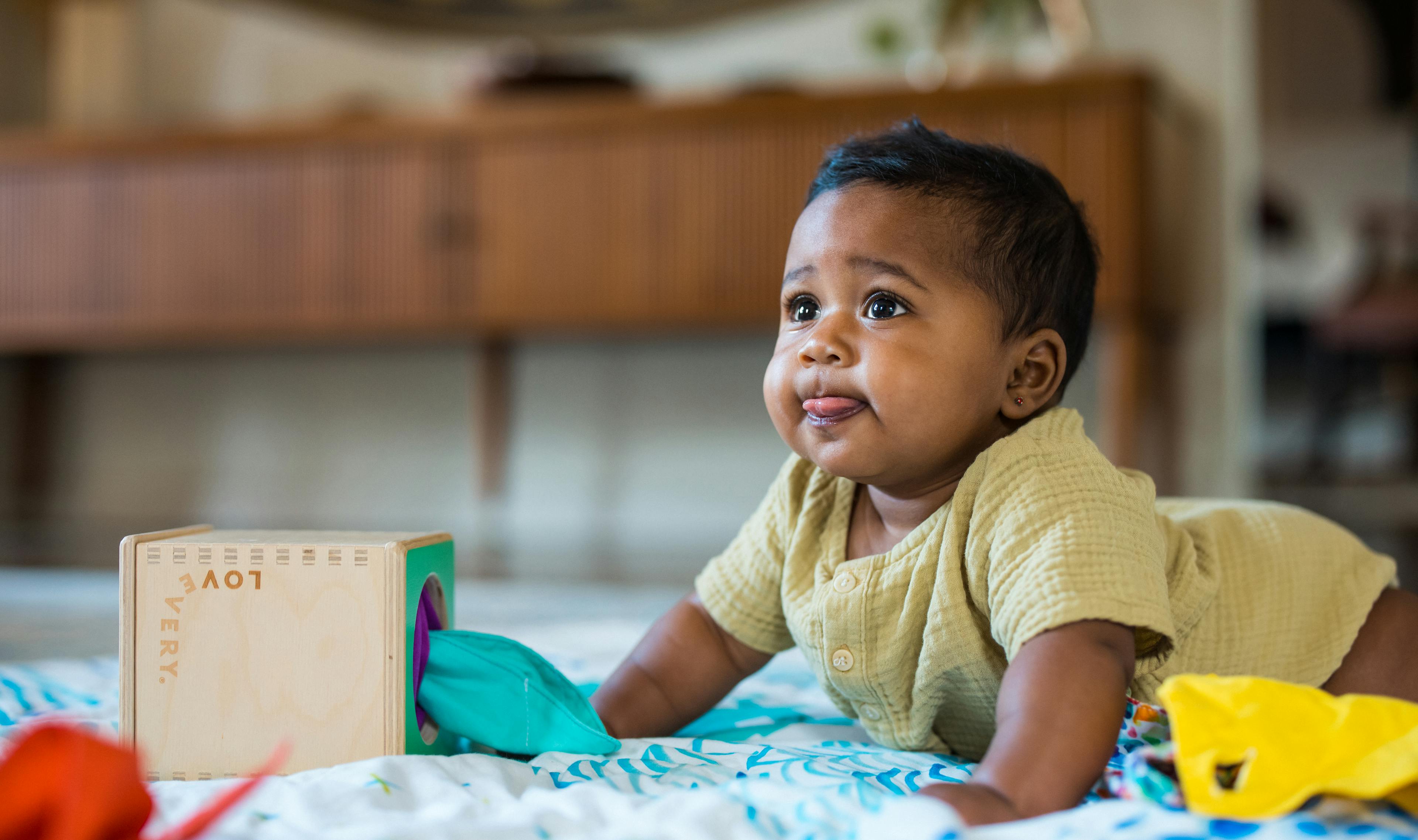 Child doing tummy time with the Magic Tissue Box from The Senser Play Kit