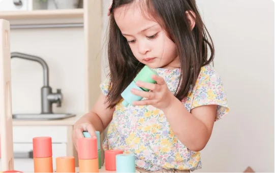 Child with the Wooden Stacking Pegboard from The Adventurer Play Kit