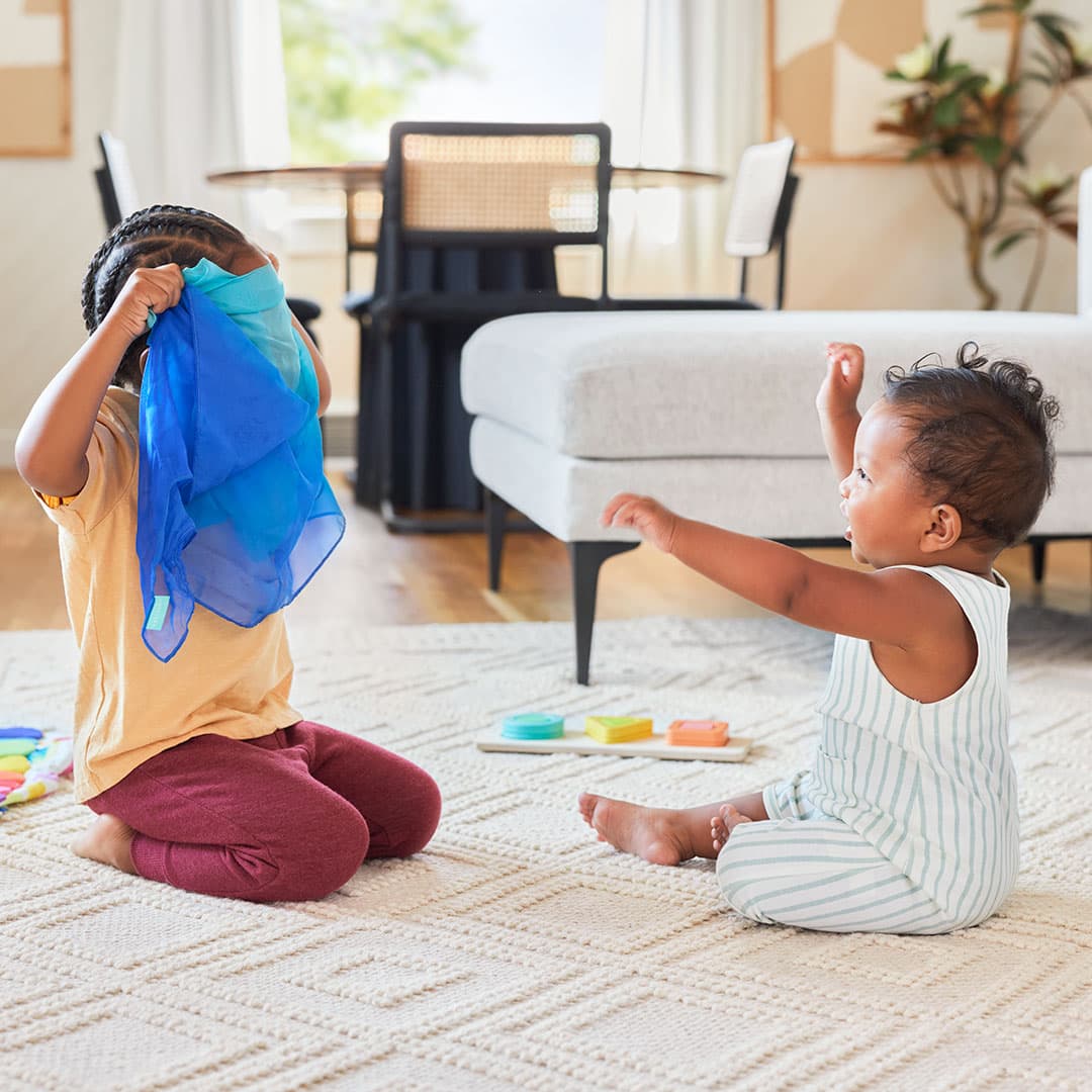 Siblings playing with Lovevery playthings