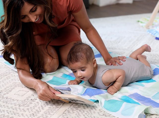 Baby doing Tummy Time while looking at the Wooden Book by Lovevery