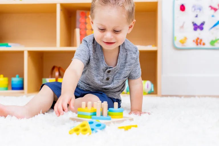 Child playing with the Sort & Stack Peg Puzzle from The Enthusiast Play Kit