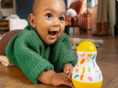 Baby playing with the Tummy Time Wobbler from The Senser Play Kit